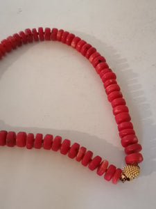 Collier en perle rouge teinté et fermoir doré. 